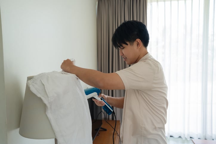 College student steaming pants. Use laundry service for students